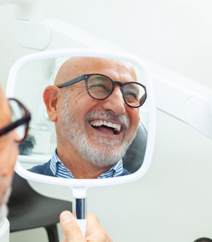man loving his new smile at the dentist
